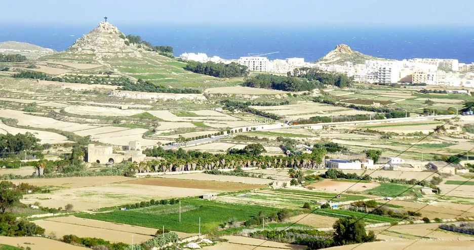 Blick über Gozo mit der Christusstatue 'Tas-Salvatur' auf dem Felshügel tal-merżuq 